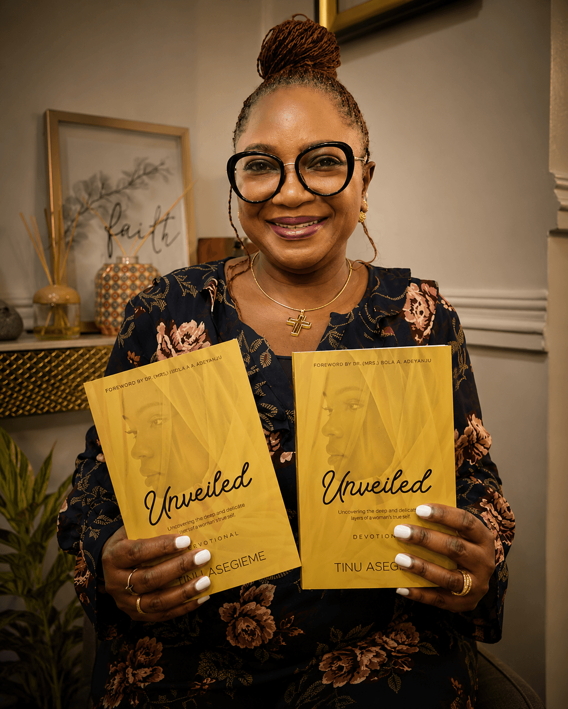 Pastor Tinu Asegieme holding copies of her book, Unveiled